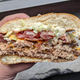 hand holding burger cut in half